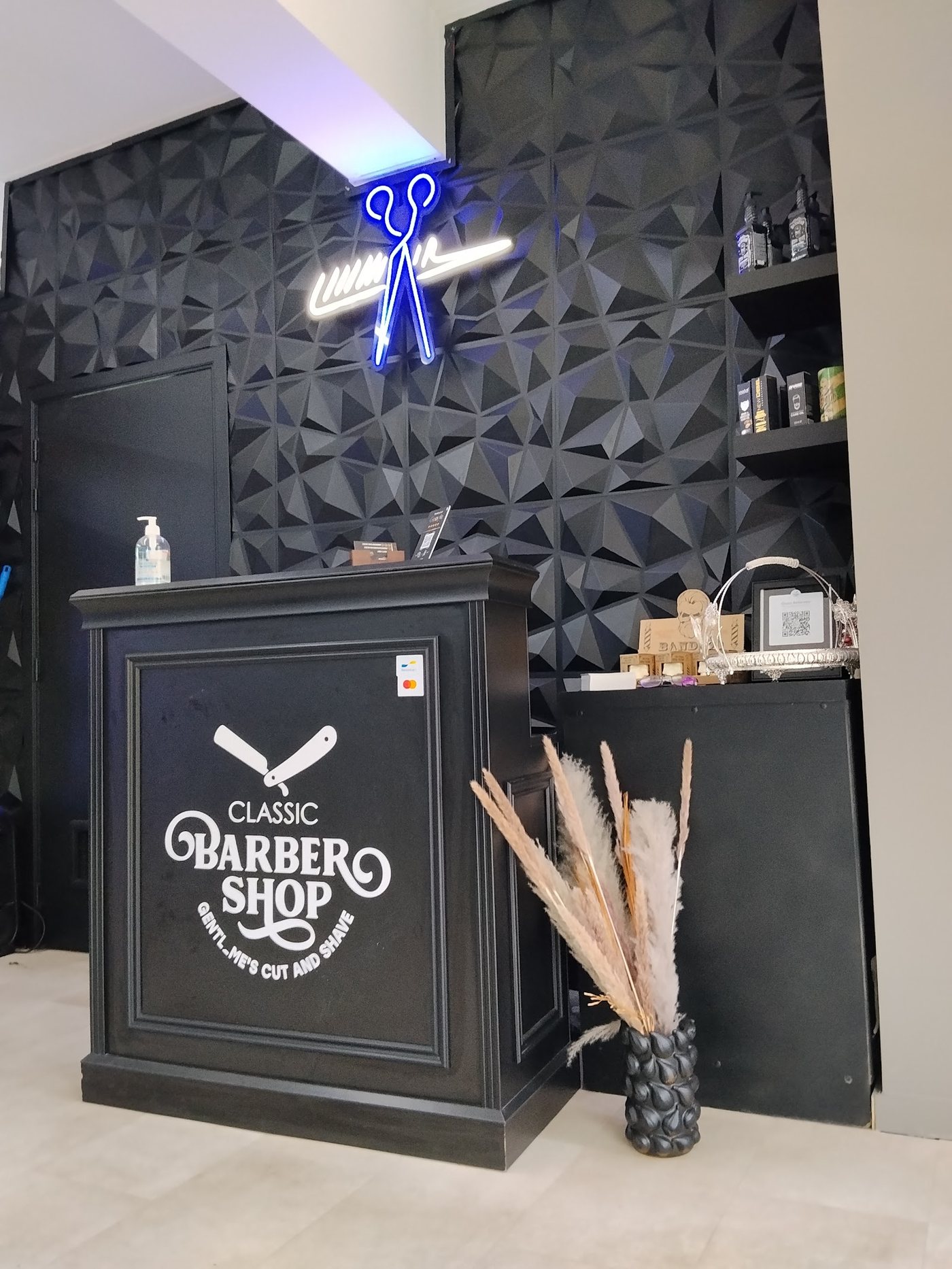 Balie met Classic Barbershop-logo en neon-schaar in Wilsele
